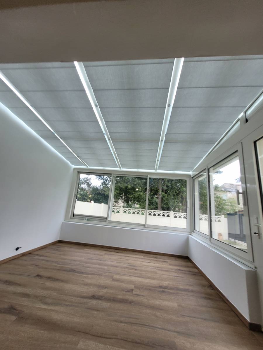 Pose de stores anti chaleur fabriqué sur mesure pour isoler de la chaleur du soleil et du froid la toiture vitrée de la véranda de nos clients situés dans Bordeaux, en Gironde.